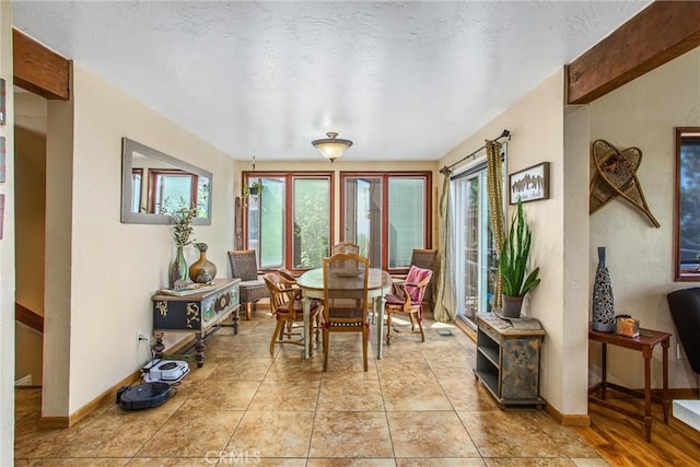 dining area featuring light tile patterned floors and a textured ceiling