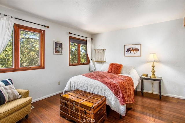 bedroom featuring multiple windows and dark hardwood / wood-style flooring