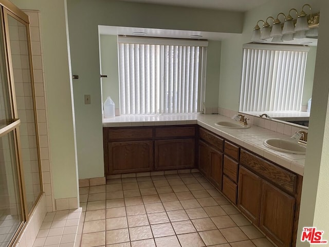 bathroom featuring vanity, a shower with shower door, and tile patterned flooring