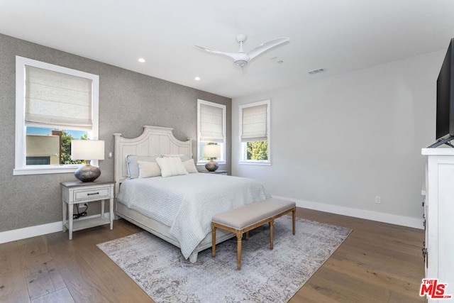 bedroom with dark hardwood / wood-style floors and ceiling fan