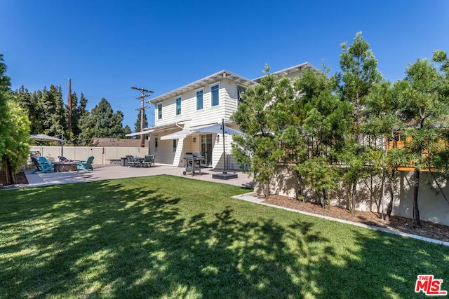 rear view of property with a yard and a patio area