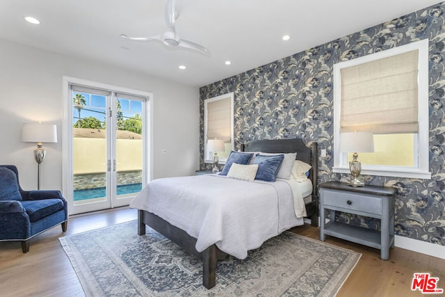 bedroom featuring wood-type flooring, access to outside, ceiling fan, and french doors