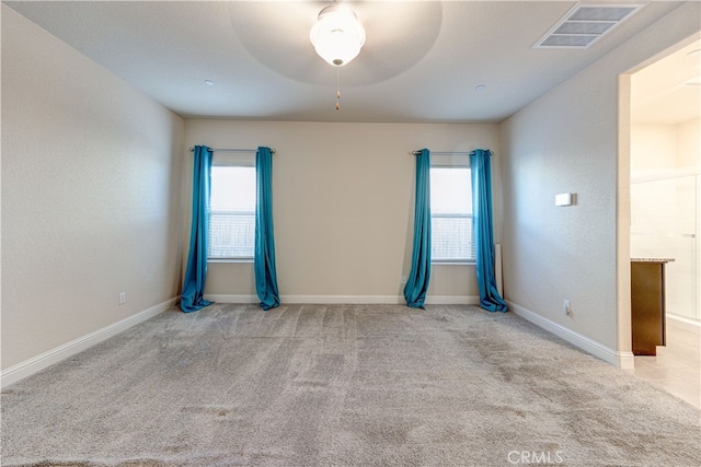 carpeted spare room featuring ceiling fan