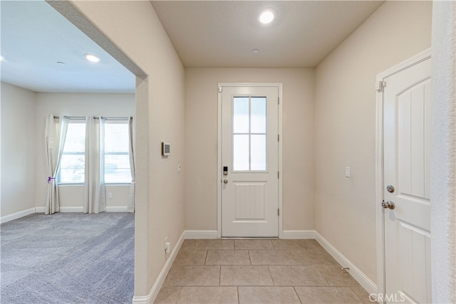 doorway featuring light colored carpet and a wealth of natural light