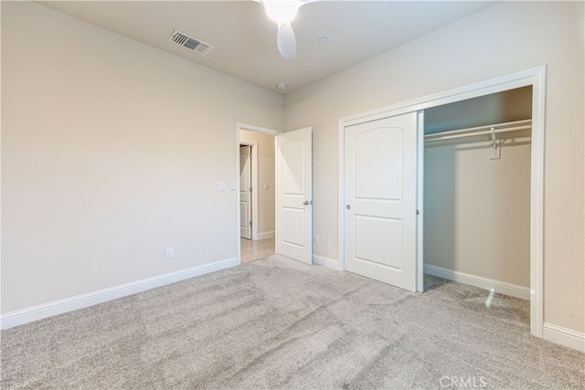 unfurnished bedroom featuring light carpet, a closet, and ceiling fan