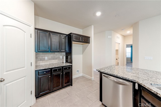 kitchen with light stone countertops, light tile patterned floors, decorative backsplash, and stainless steel dishwasher