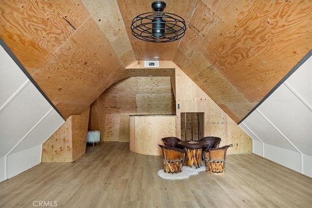 additional living space with lofted ceiling and hardwood / wood-style flooring