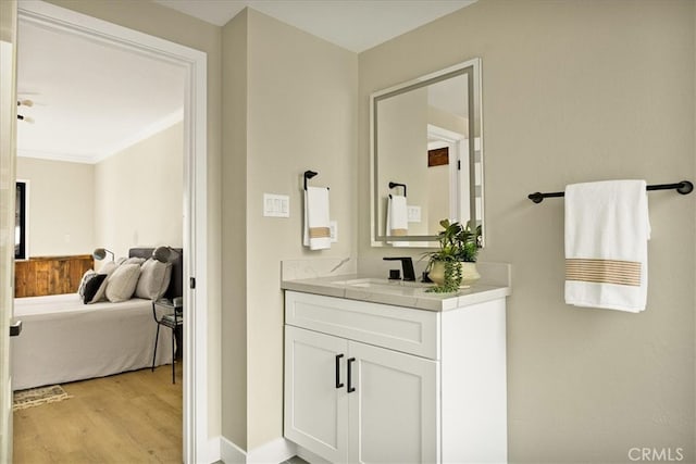 bathroom with hardwood / wood-style floors, vanity, and crown molding