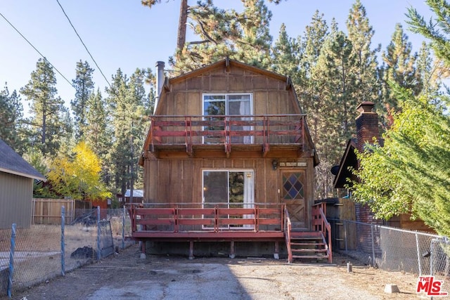 back of house with a balcony and a deck