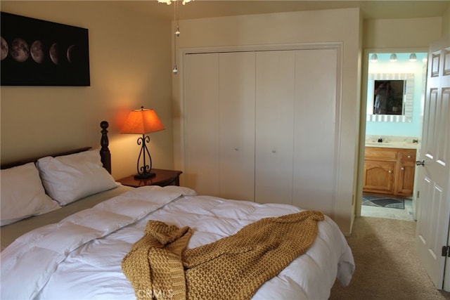 bedroom with a closet, ensuite bathroom, and light colored carpet