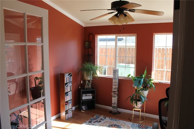 sitting room featuring ceiling fan, wood-type flooring, and ornamental molding