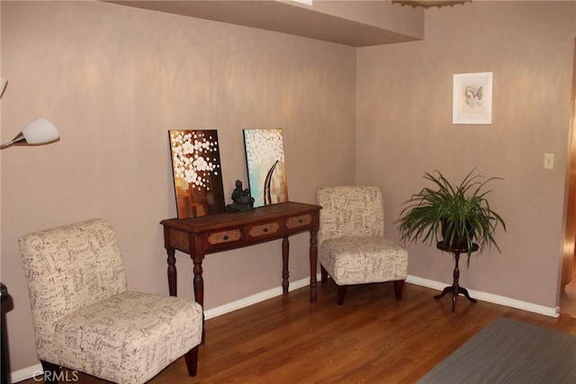 sitting room with baseboards and wood finished floors