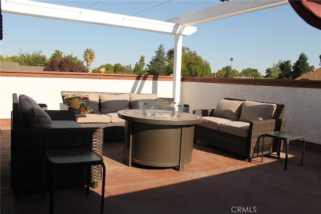 view of patio with an outdoor living space with a fire pit