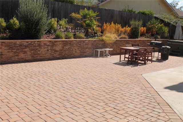 view of patio / terrace with fence, grilling area, and outdoor dining space