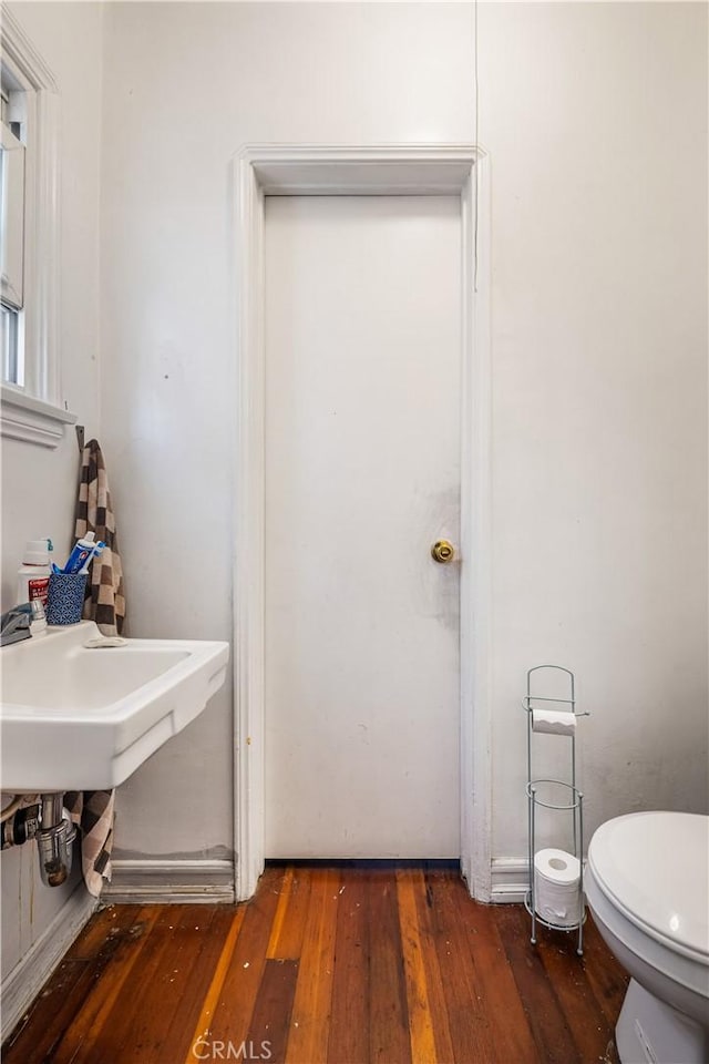 bathroom featuring hardwood / wood-style flooring and toilet