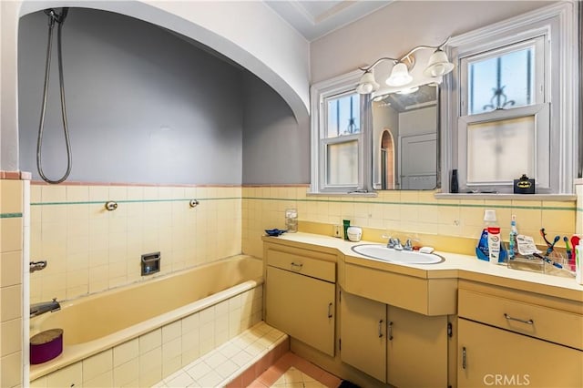 bathroom with a bathing tub, plenty of natural light, vanity, and tile patterned flooring