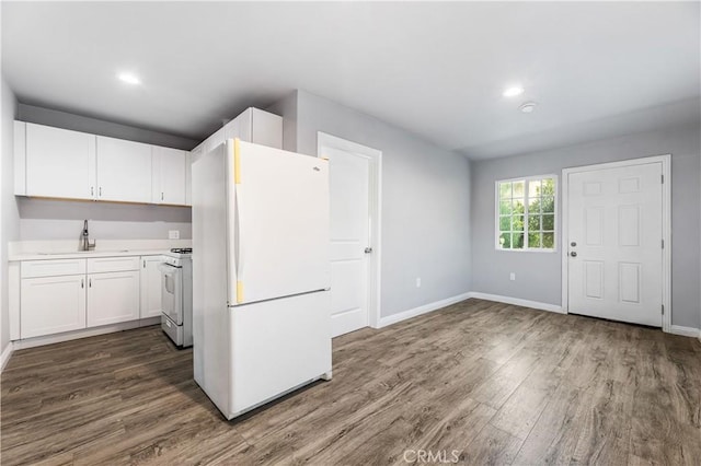 kitchen with white cabinets, white appliances, dark hardwood / wood-style floors, and sink