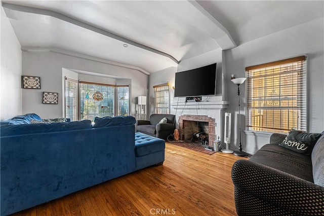 living room with a fireplace, wood-type flooring, vaulted ceiling, and crown molding