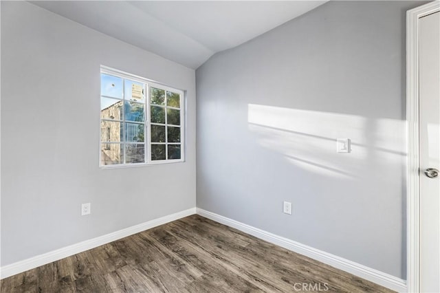 spare room with hardwood / wood-style flooring and vaulted ceiling