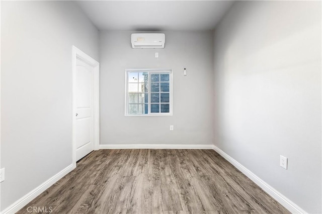 unfurnished room featuring wood-type flooring and a wall mounted AC