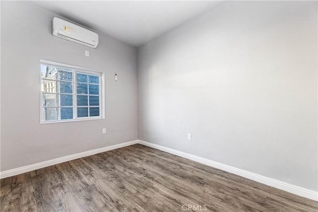 unfurnished room with a wall mounted air conditioner and hardwood / wood-style floors