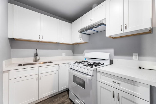 kitchen with white cabinetry, sink, dark hardwood / wood-style flooring, range hood, and white gas range oven