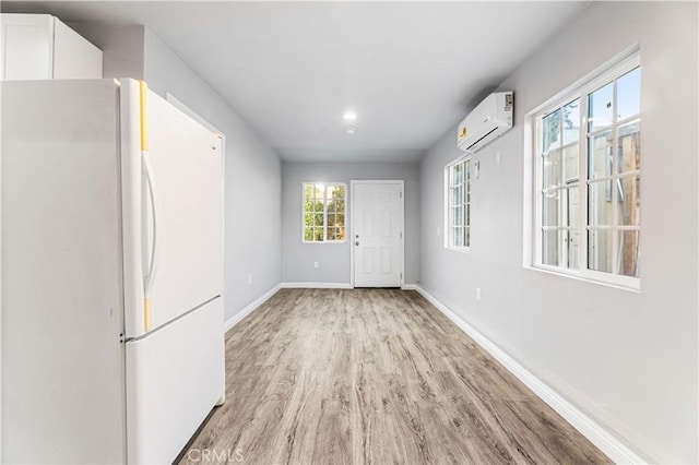 interior space featuring light hardwood / wood-style floors and a wall mounted air conditioner