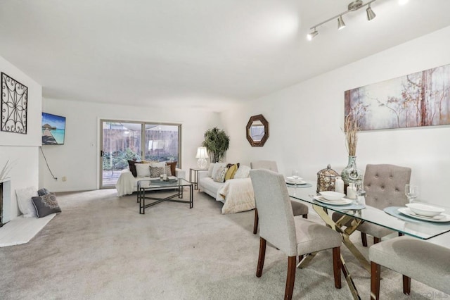 dining room with light carpet and rail lighting