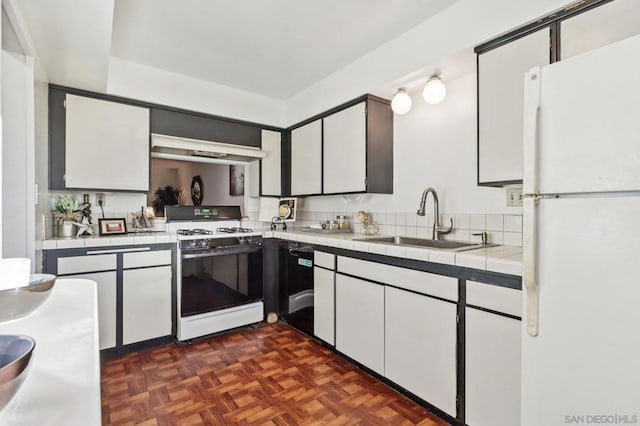 kitchen featuring white cabinets, sink, white appliances, dark parquet flooring, and range hood