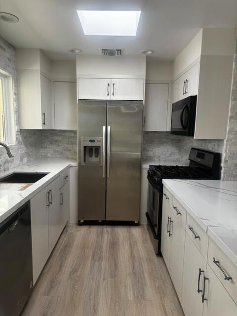 kitchen with black appliances and white cabinetry