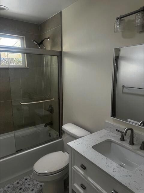 full bathroom with vanity, toilet, and enclosed tub / shower combo