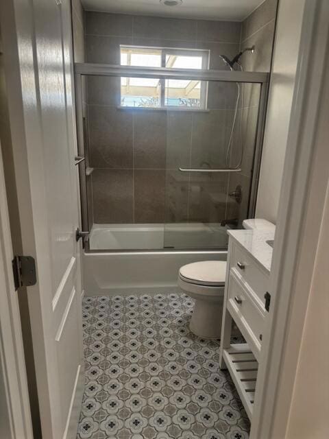 full bathroom with toilet, enclosed tub / shower combo, and vanity