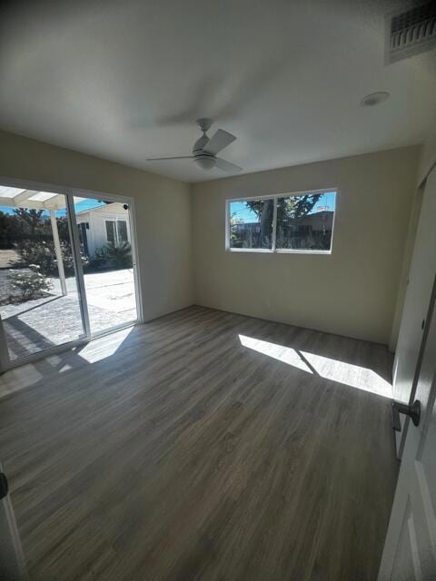 unfurnished room with ceiling fan and dark hardwood / wood-style flooring