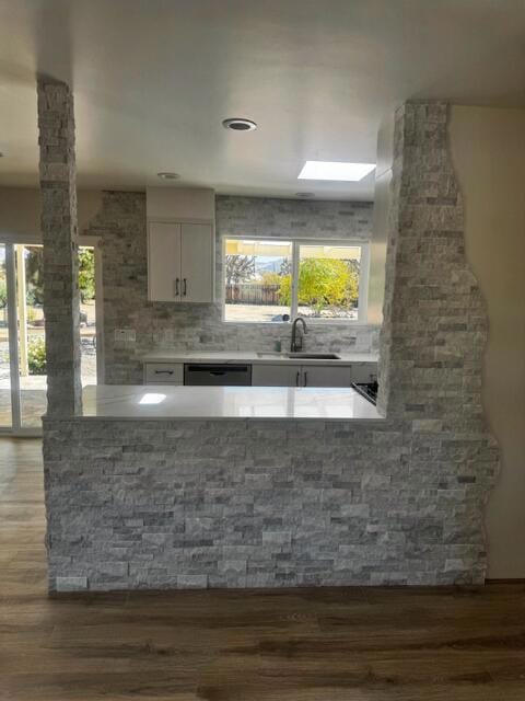 kitchen with dark hardwood / wood-style flooring, sink, white cabinets, and plenty of natural light