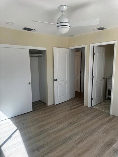 unfurnished bedroom featuring a closet and hardwood / wood-style flooring