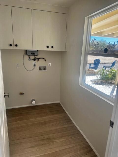 clothes washing area featuring washer hookup, dark hardwood / wood-style flooring, water heater, and cabinets