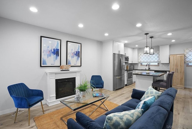 living room with light hardwood / wood-style floors and sink