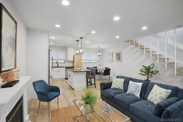 living room with light hardwood / wood-style flooring and sink