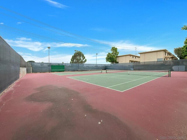 view of tennis court with basketball hoop