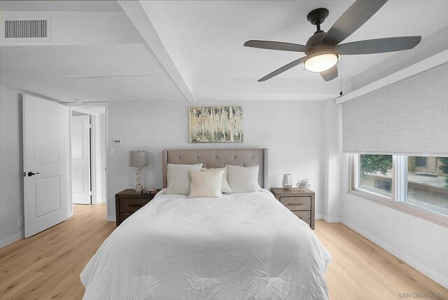 bedroom with ceiling fan, beam ceiling, and light hardwood / wood-style flooring