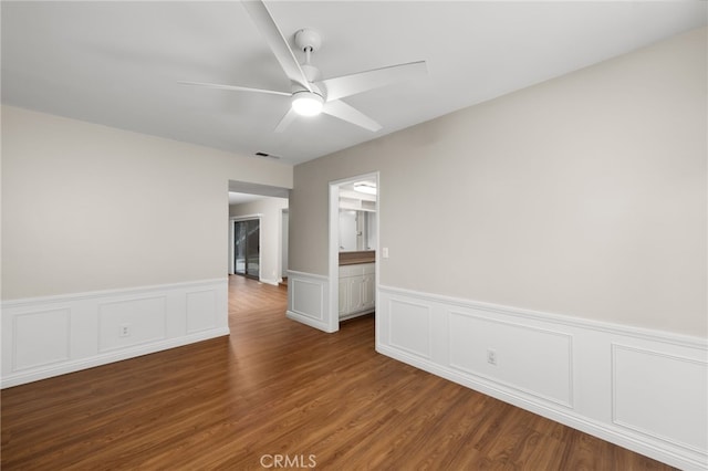 empty room with ceiling fan and dark hardwood / wood-style floors