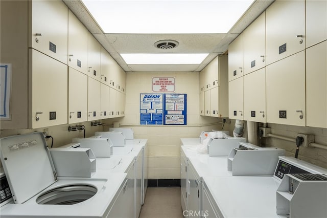 laundry room featuring separate washer and dryer and cabinets