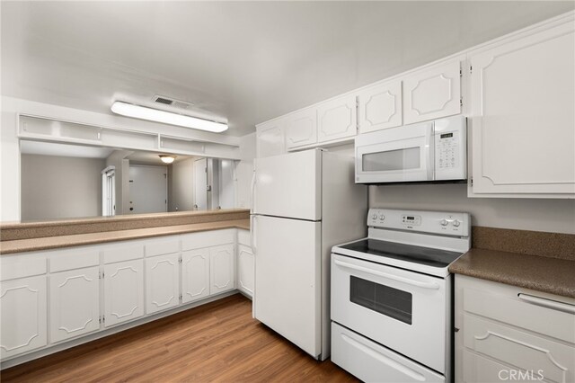 kitchen with light hardwood / wood-style floors, white cabinets, and white appliances