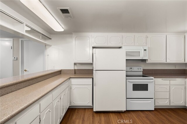 kitchen with white cabinetry, dark hardwood / wood-style floors, and white appliances