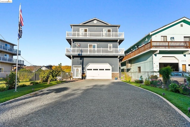 view of front of property with a balcony, a garage, and a front lawn