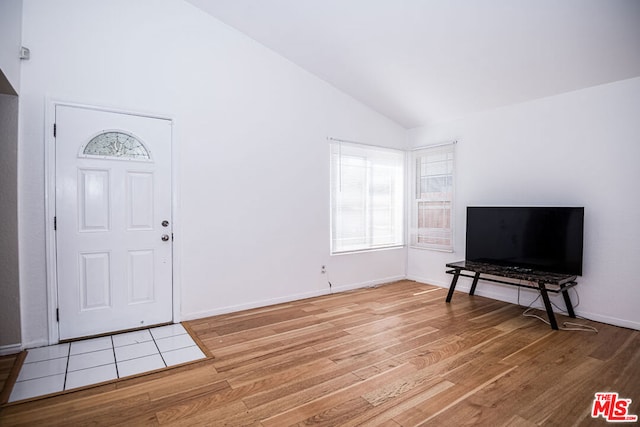 foyer with vaulted ceiling and light wood-type flooring