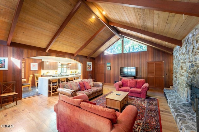 living room with wood ceiling, light hardwood / wood-style floors, wood walls, high vaulted ceiling, and beam ceiling