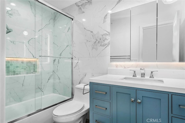 full bathroom featuring vanity, tasteful backsplash, bath / shower combo with glass door, tile walls, and toilet