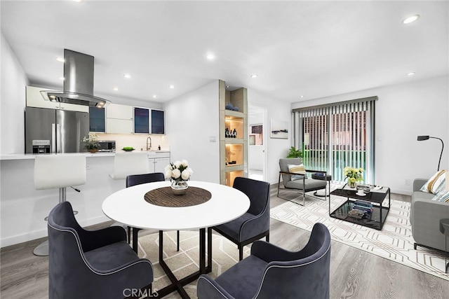 dining room featuring sink and light hardwood / wood-style floors