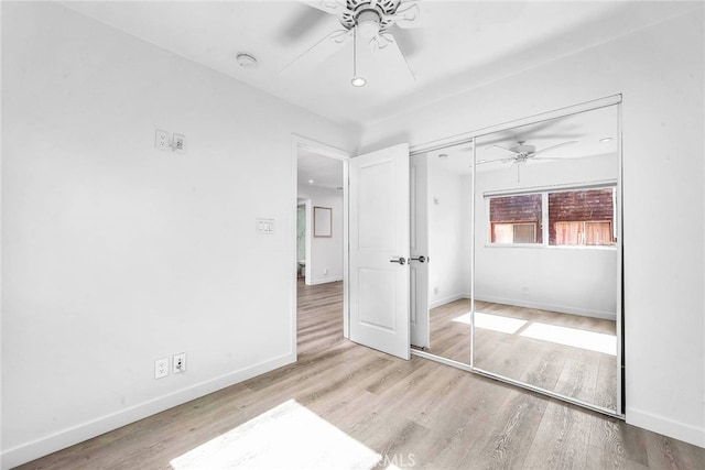 unfurnished bedroom with a closet, light hardwood / wood-style floors, and ceiling fan